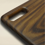 Wooden cutting board with a handle on a beige background