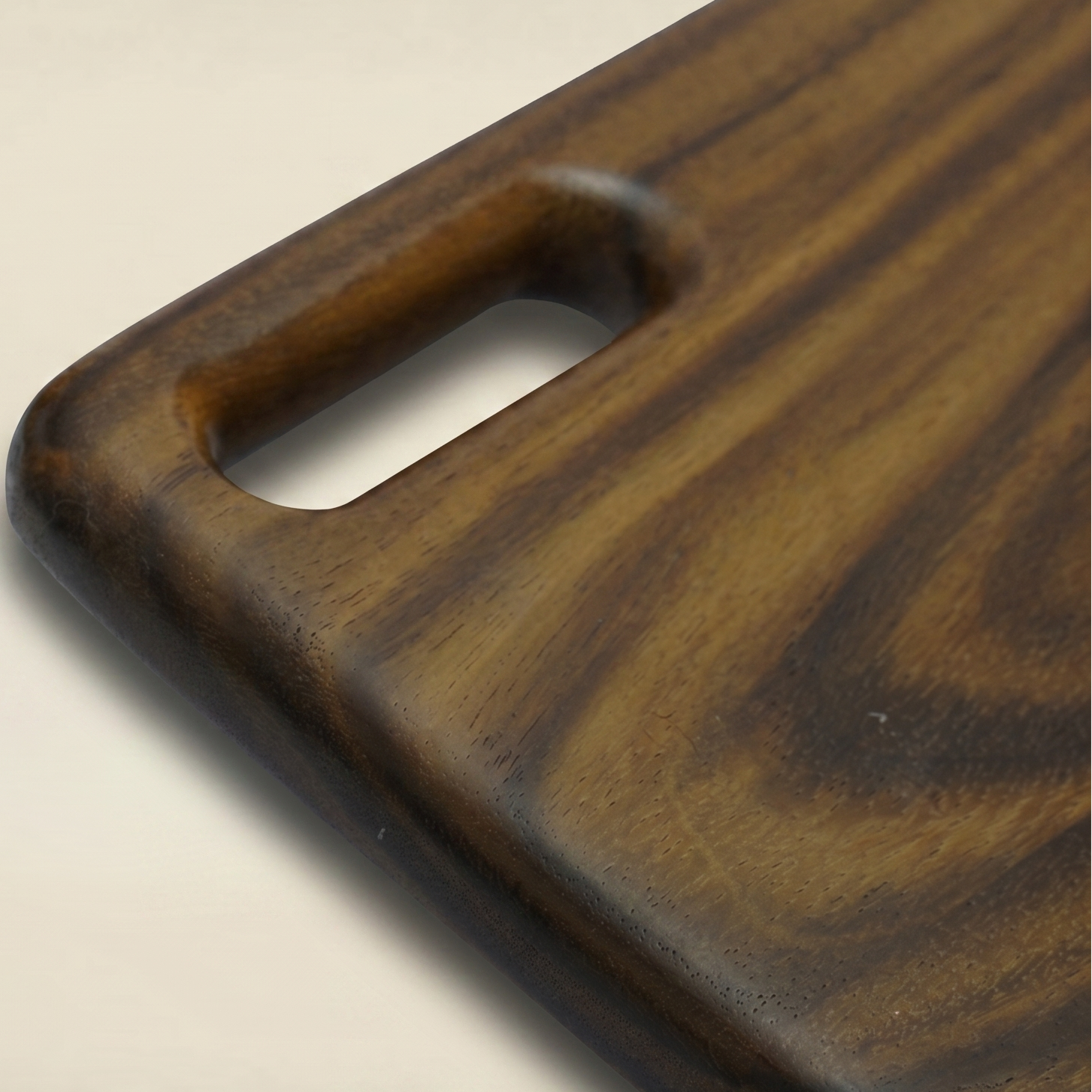 Wooden cutting board with a handle on a beige background