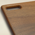 Wooden cutting board with a handle on a beige background
