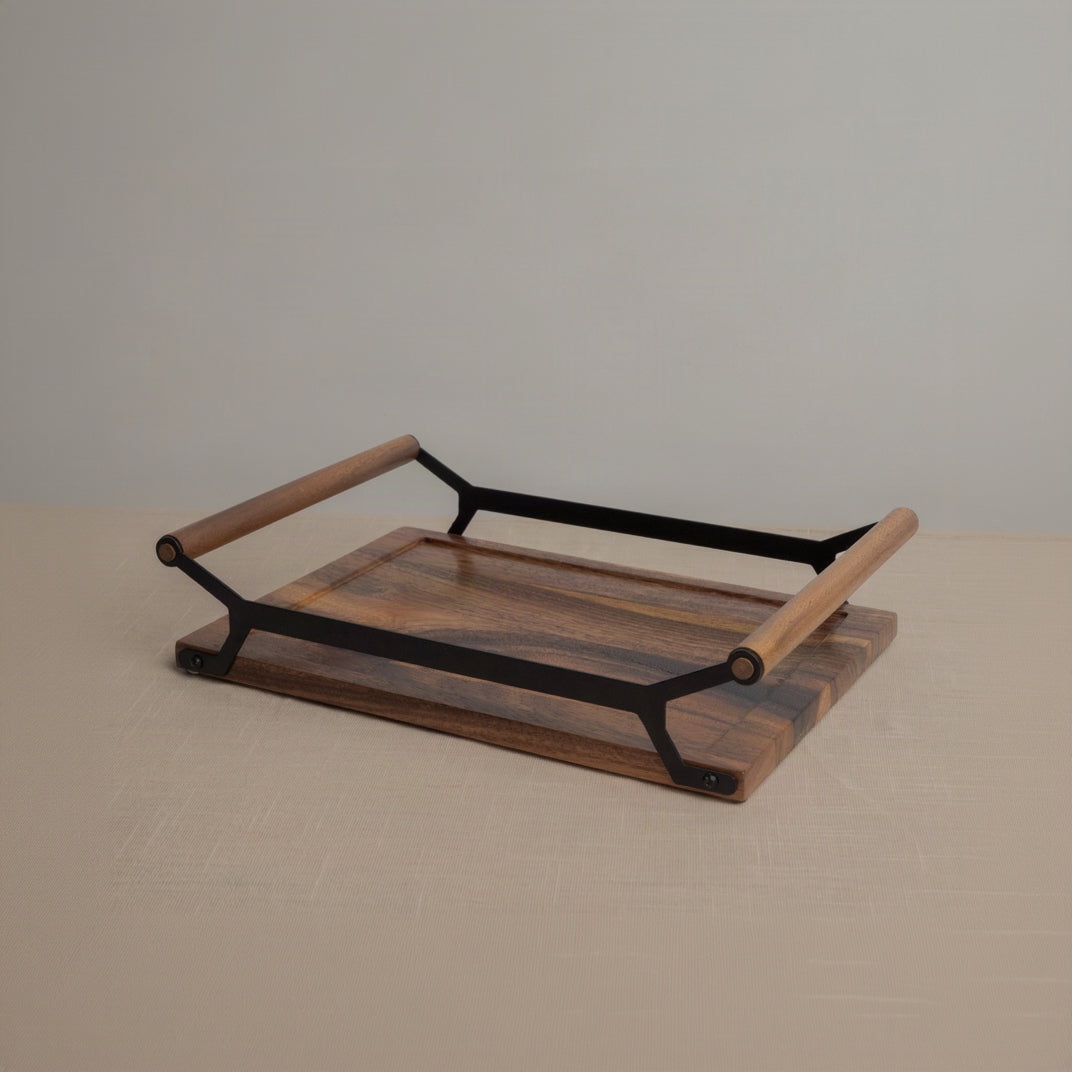 A rectangular wooden serving tray with a rich medium-brown wood grain and a black metal frame with light wood handles, set against a neutral beige background.